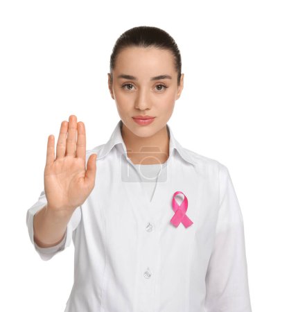Mammologist with pink ribbon showing stop gesture on white background. Breast cancer awareness