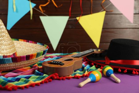Téléchargez les photos : Chapeaux mexicains sombrero et noir flamenco, ukulélé et maracas sur table violette, gros plan - en image libre de droit