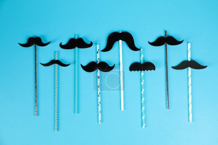 Téléchargez les photos : Moustaches en papier faux avec accessoires de fête sur fond bleu clair, pose plate - en image libre de droit