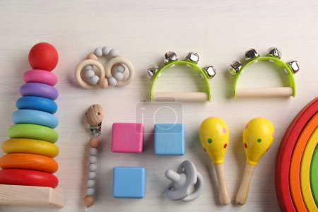 Babygesangskonzept. Flache Lagekomposition mit Spielzeug-Musikinstrumenten auf weißem Holzgrund