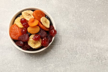 Téléchargez les photos : Mélange de délicieux fruits secs sur table grise, vue de dessus. Espace pour le texte - en image libre de droit