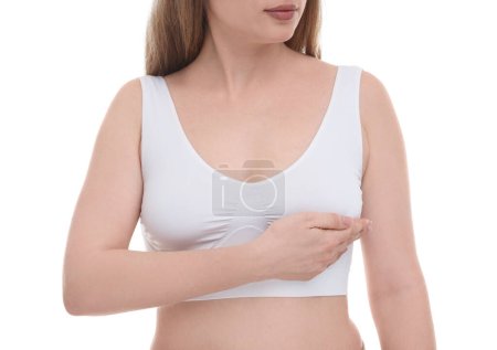 Mammologie. Jeune femme faisant l'auto-examen du sein sur fond blanc, gros plan