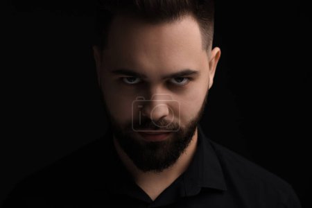 Photo for Evil eye. Man with scary eyes on black background - Royalty Free Image