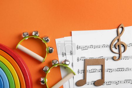 Herramientas para crear canciones para bebés. Composición plana con panderetas para niños sobre fondo naranja