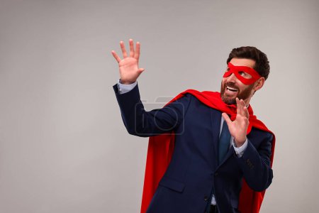 Foto de Hombre de negocios con capa de superhéroe rojo y máscara sobre fondo beige. Espacio para texto - Imagen libre de derechos