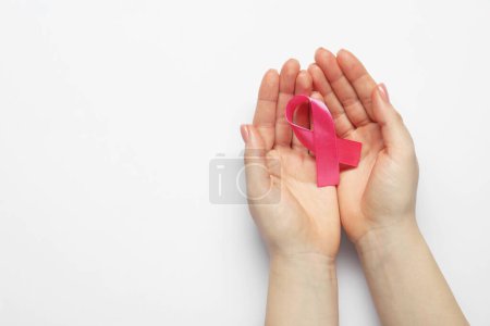 Sensibilisation au cancer du sein. Femme avec ruban rose sur fond blanc, vue de dessus. Espace pour le texte