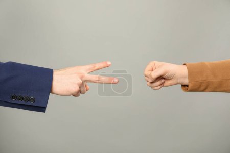 Photo for People playing rock, paper and scissors on grey background, closeup - Royalty Free Image