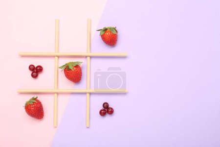 Tic tac toe game made with berries on color background, top view. Space for text