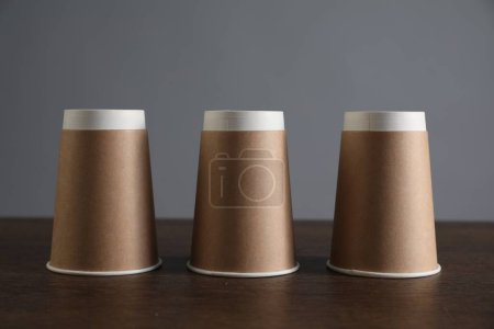 Shell game. Three paper cups on wooden table