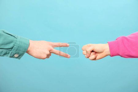 Photo for People playing rock, paper and scissors on light blue background, closeup - Royalty Free Image