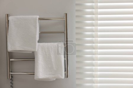 Photo for Heated towel rail with towels in bathroom - Royalty Free Image