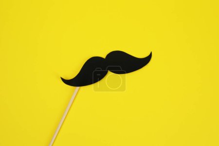 Téléchargez les photos : Fausse moustache en papier avec bâton sur fond jaune, vue de dessus - en image libre de droit