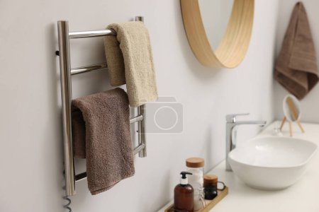 Beheizter Handtuchhalter mit braunen Handtüchern im Badezimmer