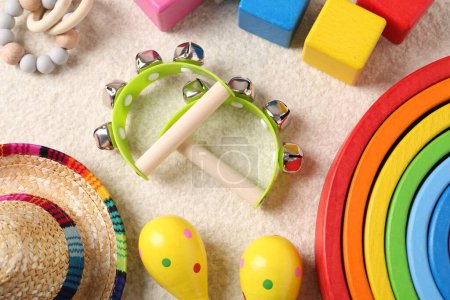 Photo for Baby song concept. Wooden tambourines and toys on beige carpet, flat lay - Royalty Free Image