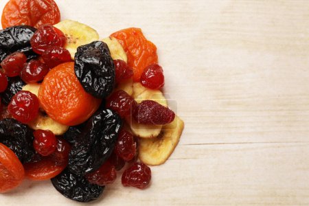 Téléchargez les photos : Mélange de délicieux fruits secs sur une table en bois blanc, vue sur le dessus. Espace pour le texte - en image libre de droit