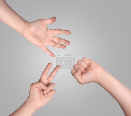 Photo for People playing rock, paper and scissors on grey background, top view - Royalty Free Image