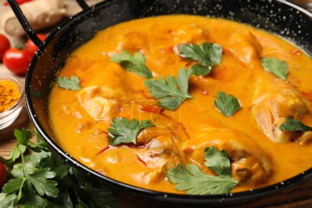 Curry de poulet savoureux avec du persil sur la table, gros plan