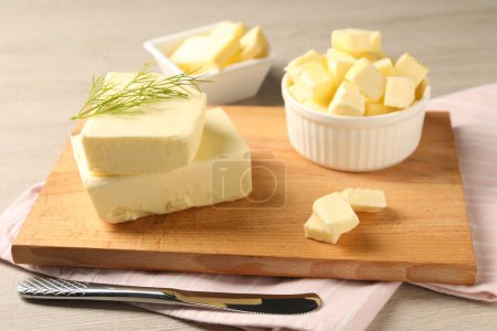 Tasty butter with dill and knife on wooden table