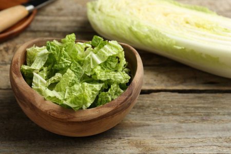 Cut fresh Chinese cabbage on wooden table, closeup