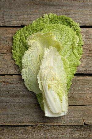 Cut fresh Chinese cabbage on wooden table, top view