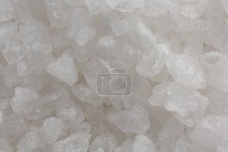 White natural salt as background, top view