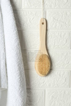 Photo for Bath accessories. Bamboo brush and terry towel on white brick wall - Royalty Free Image