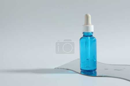 Botella con producto cosmético sobre fondo claro, espacio para texto