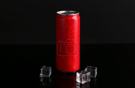 Bebida energética en lata húmeda y cubitos de hielo sobre fondo negro