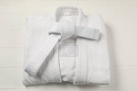 Photo for White karate belt and kimono on wooden background, top view - Royalty Free Image