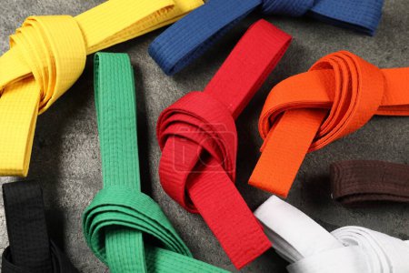 Cinturones de karate de colores sobre fondo gris, planas