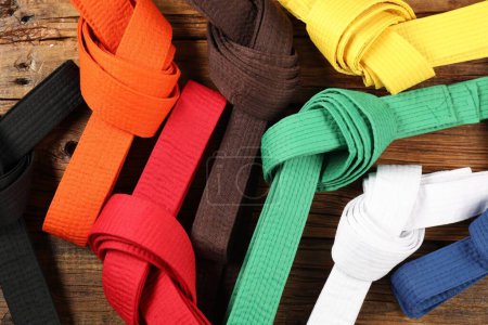 Photo for Colorful karate belts on wooden background, flat lay - Royalty Free Image
