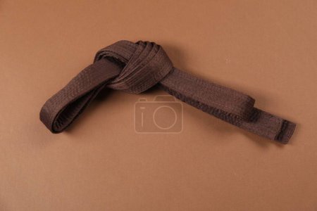 Cinturón de karate sobre fondo marrón. Uniforme de artes marciales