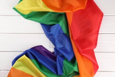 Bandera Rainbow LGBT en mesa de madera blanca, vista superior