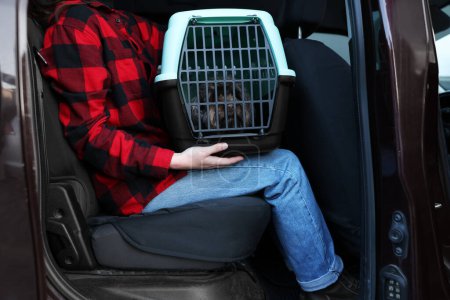 Frau mit Tragetuch, die mit ihrem Hund im Auto unterwegs ist, Nahaufnahme. Sicherer Transport