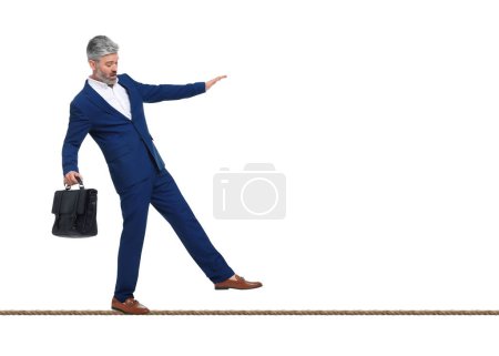 Risiken und Herausforderungen des Unternehmensbesitzes. Mann mit Aktentasche balanciert auf Seil vor weißem Hintergrund