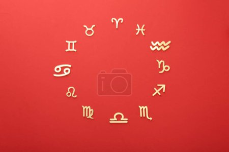 Foto de Signos del zodíaco sobre fondo rojo, posición plana - Imagen libre de derechos