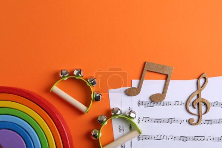 Werkzeuge zum Erstellen von Babyliedern. Flache Komposition mit Tamburinen für Kinder auf orangefarbenem Hintergrund. Raum für Text