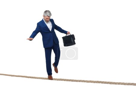 Photo for Risks and challenges of owning business. Man with briefcase balancing on rope against white background - Royalty Free Image