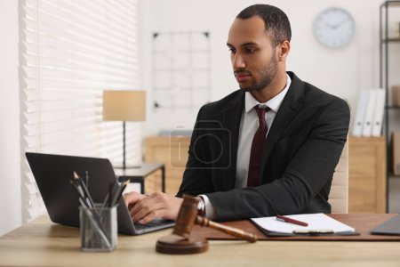 Photo for Serious lawyer working with laptop at table in office - Royalty Free Image