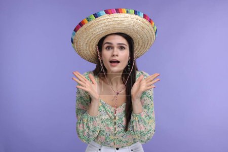 Mujer sorprendida en sombrero mexicano sombrero sobre fondo violeta