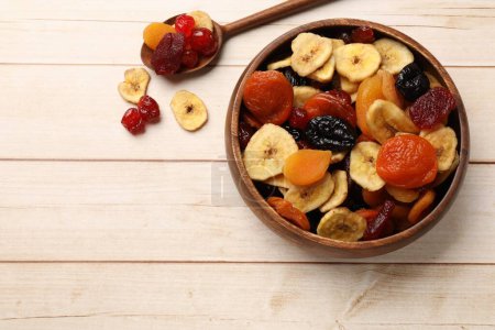 Téléchargez les photos : Mélange de délicieux fruits secs sur une table en bois blanc, à plat. Espace pour le texte - en image libre de droit