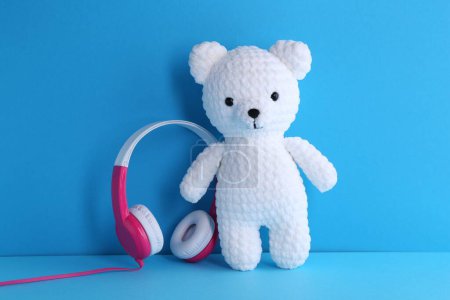 Babylieder. Spielzeugbär und Kopfhörer auf hellblauem Hintergrund