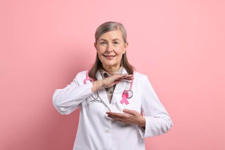 Mammologist with pink ribbon on color background. Breast cancer awareness