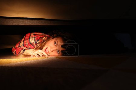 Téléchargez les photos : La phobie de l'enfance. Petite fille avec monstre sous le lit à la maison, gros plan - en image libre de droit