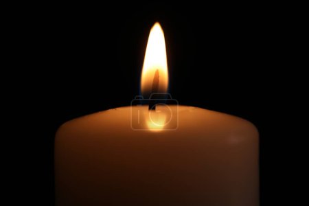 Brennende Kerze in der Dunkelheit, Nahaufnahme. Gedenktag