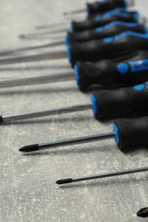 Set of screwdrivers on grey table, closeup