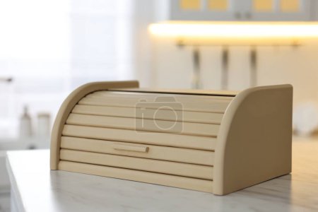 Caja de pan de madera sobre mesa blanca en cocina, primer plano