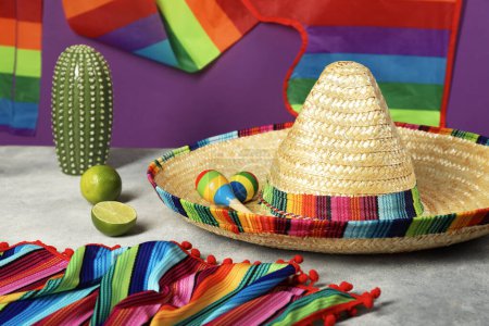 Composition avec chapeau de sombrero mexicain et maracas sur table grise