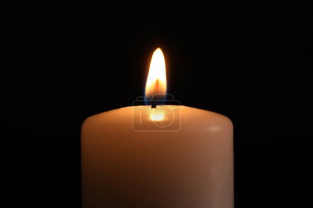 Brennende Kerze in der Dunkelheit, Nahaufnahme. Gedenktag