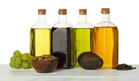 Photo for Vegetable fats. Bottles of different cooking oils and ingredients on wooden table against white background - Royalty Free Image